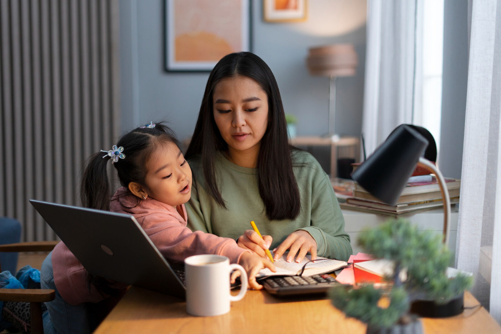 woman working on homework with child watching